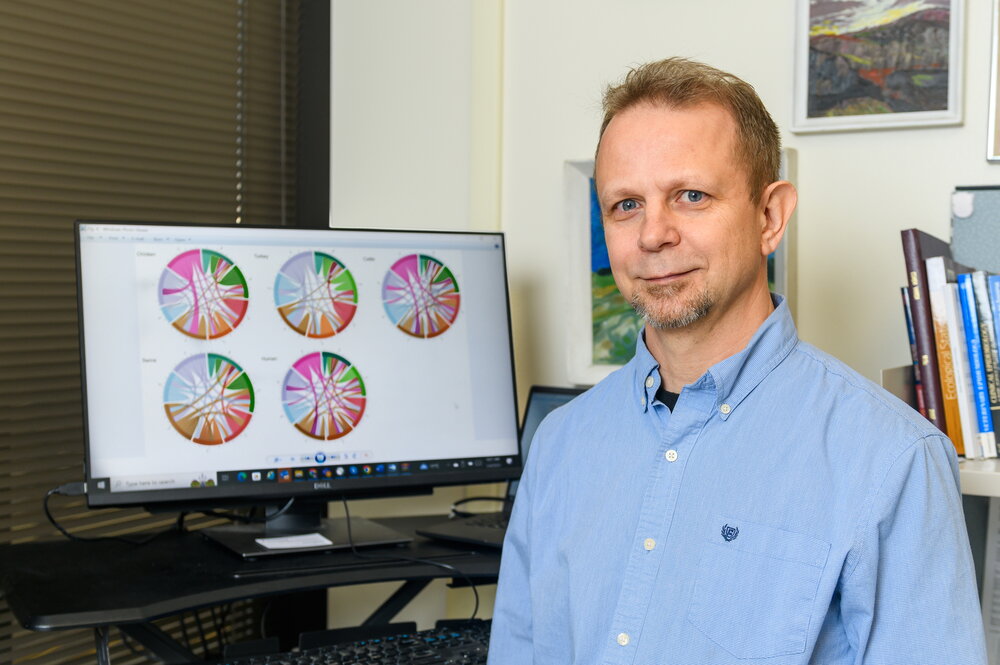 A headshot of professor Csaba Varga next to a chart